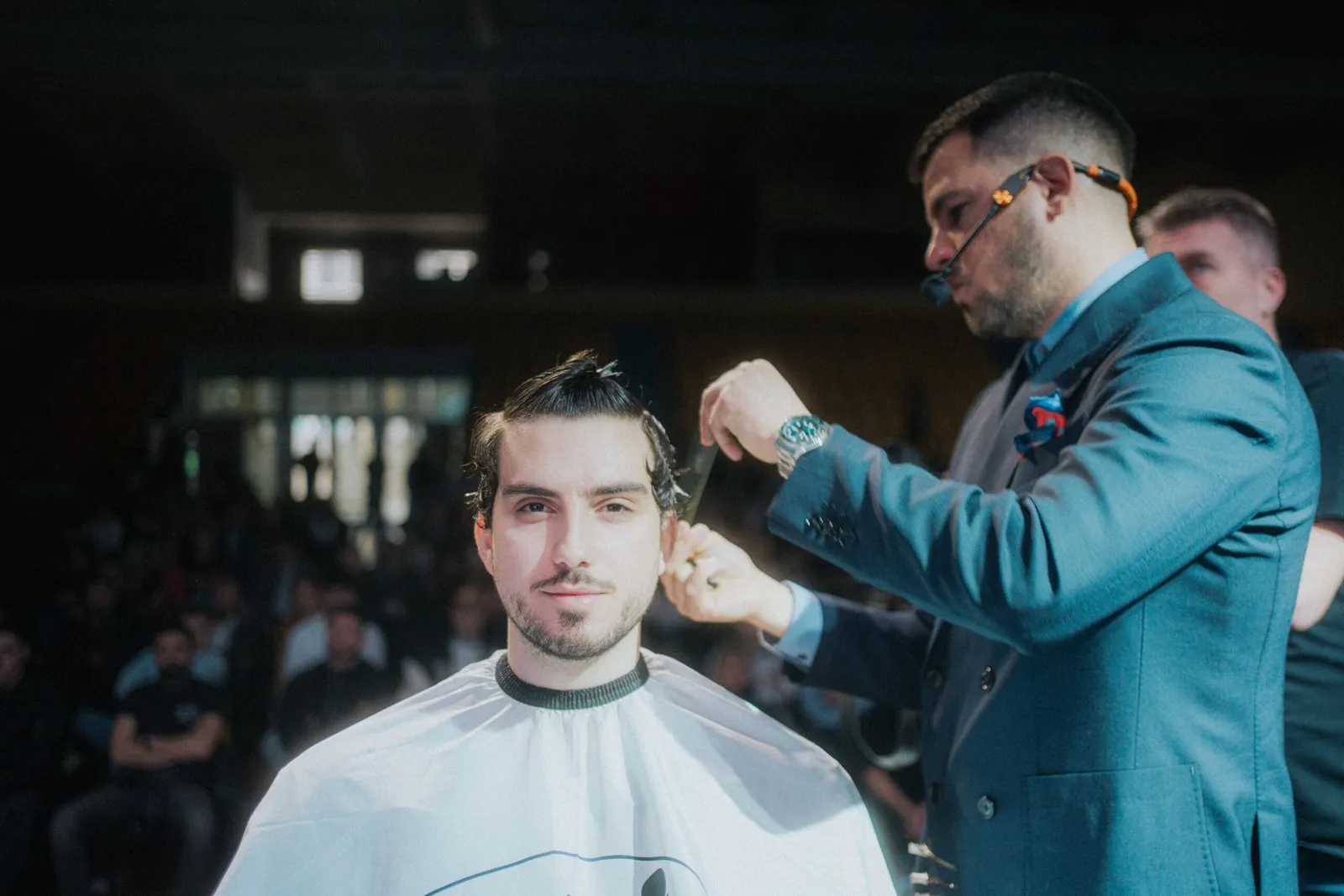 Barber šiša klijenta u zatamnjenom salonu