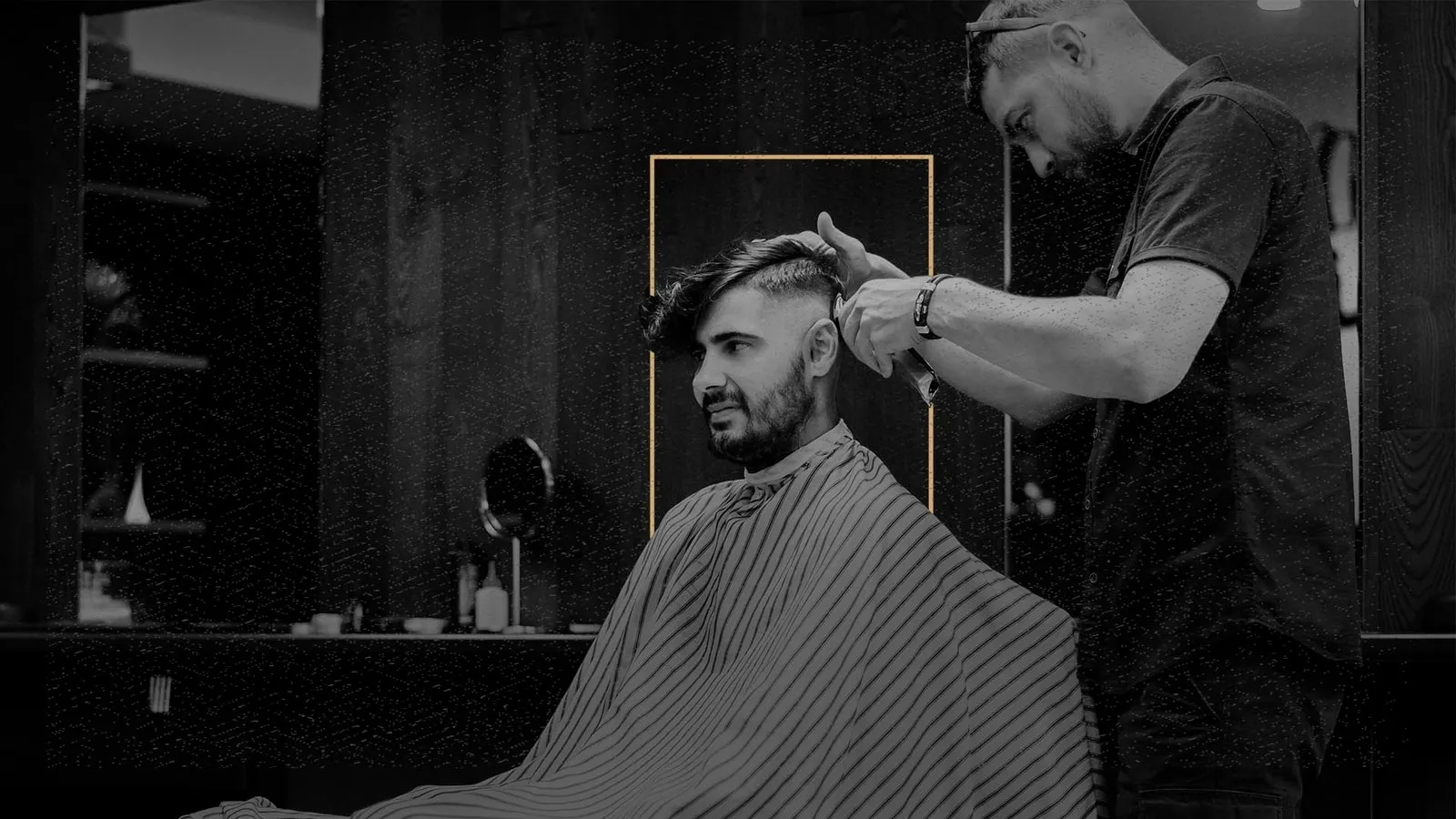 Majstor oblikuje frizuru u zatamnjenom salonu